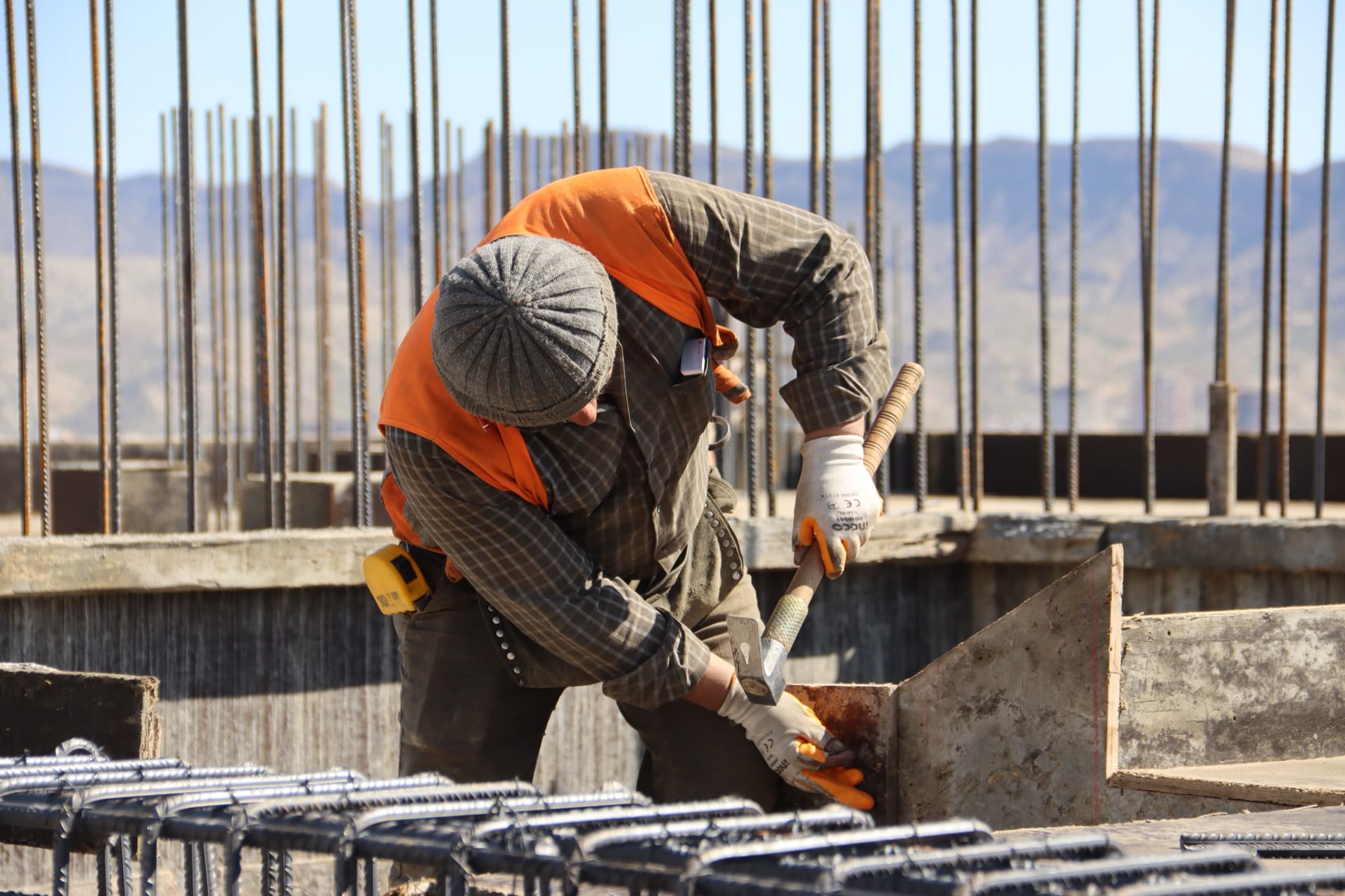Un ferrailleur assemble les armatures d'une dalle, sur un chantier