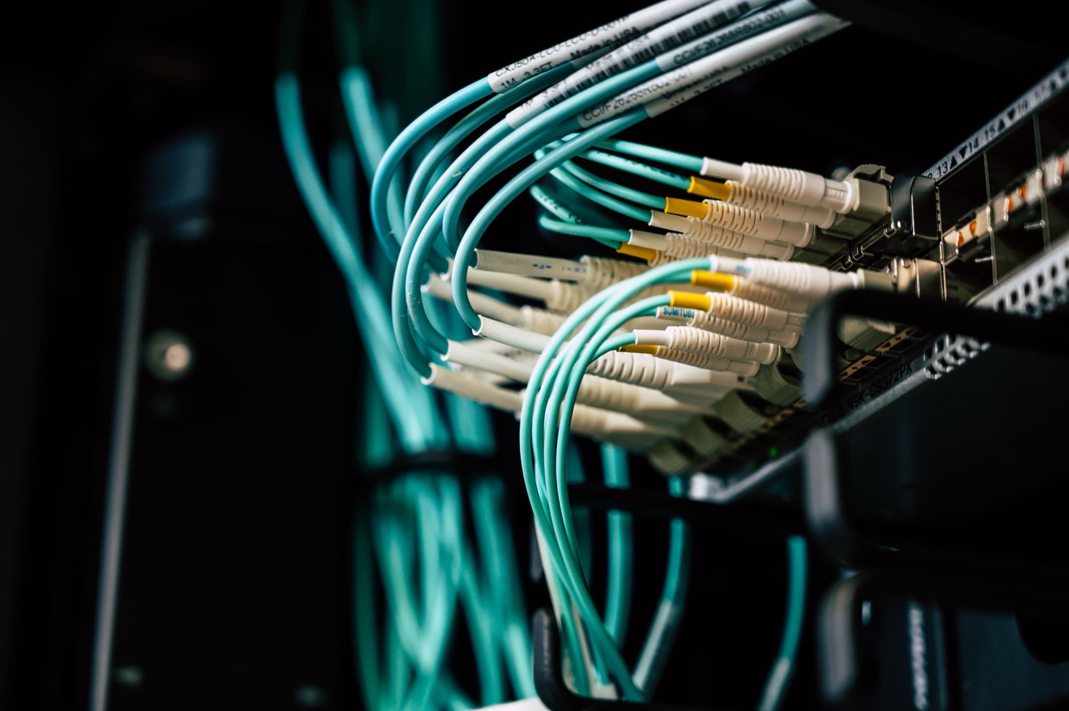 Des fibres optiques branchées sur un panneau, dans la pénombre