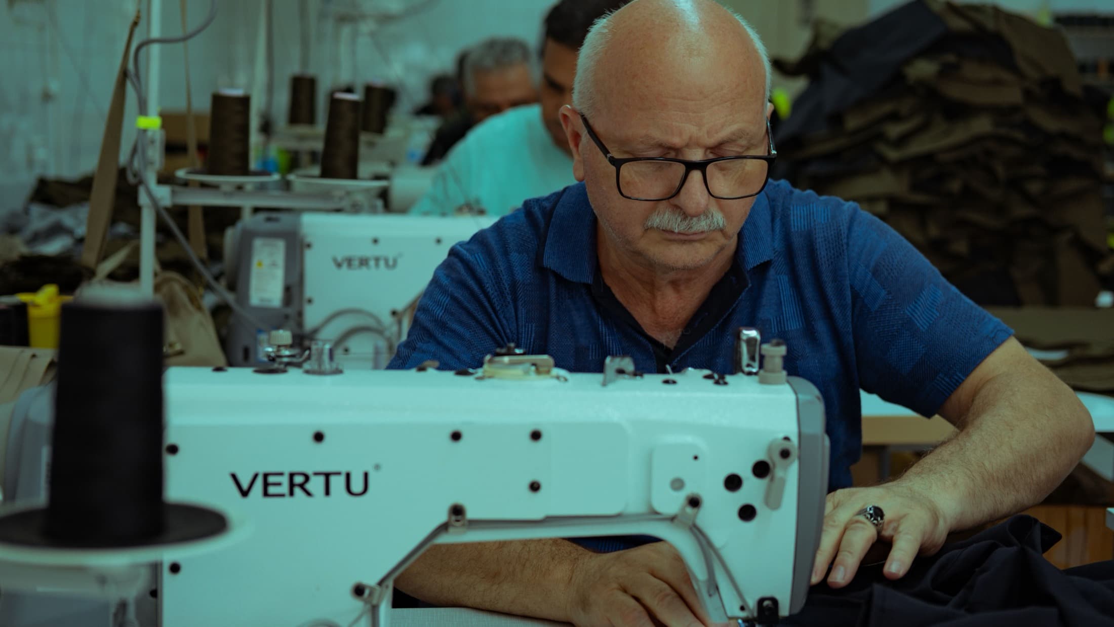Un ouvrier expérimenté travaille à sa machine, dans un atelier de confection