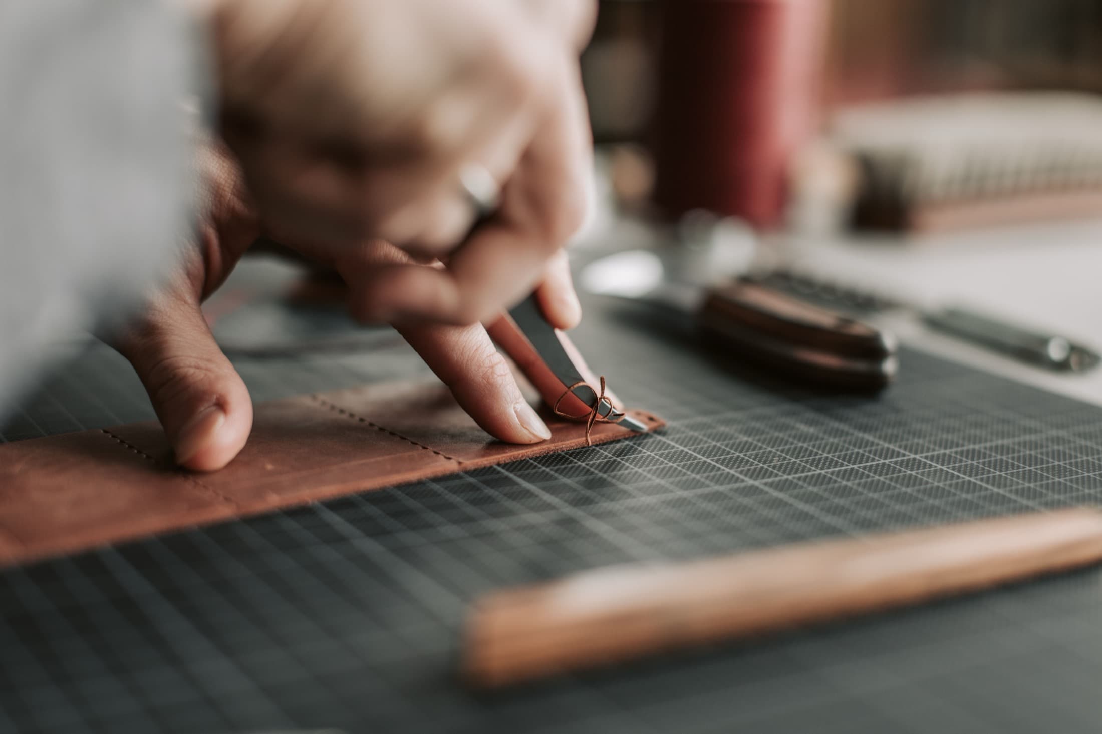 Un artisan trace une découpe sur une pièce de cuir