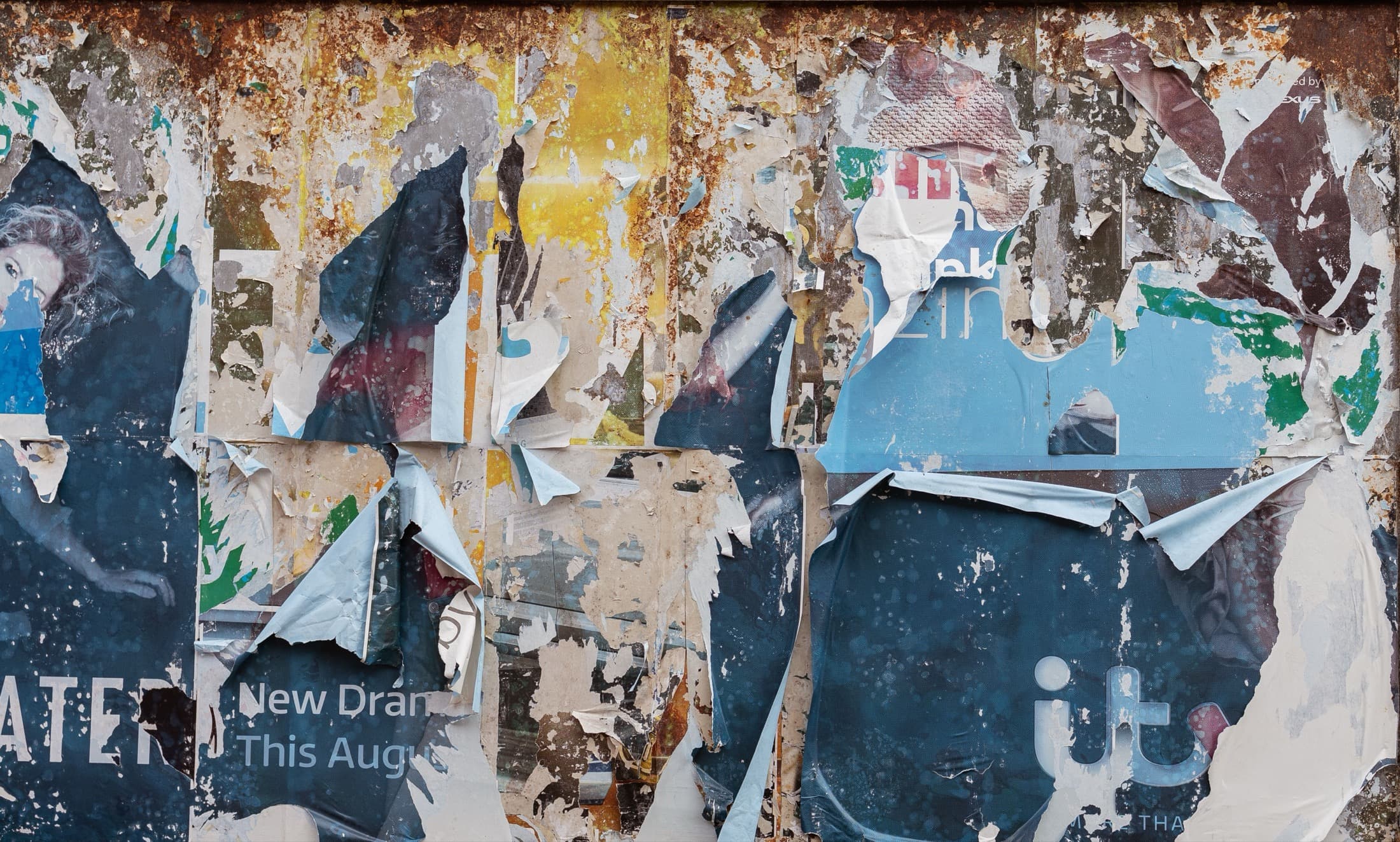 Des couches d'affiches arrachées sur un mur