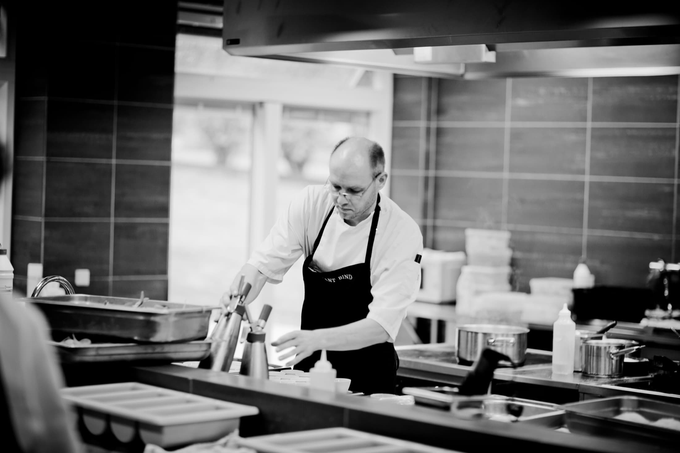 Un chef travaille seul au passe, en cuisine