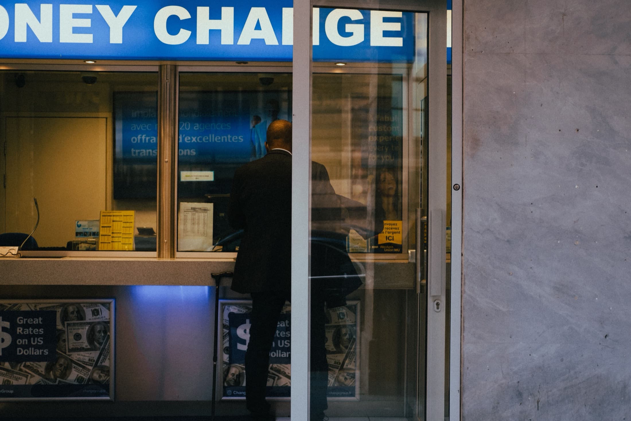 Un guichet bancaire vu depuis la rue, à la tombée du jour
