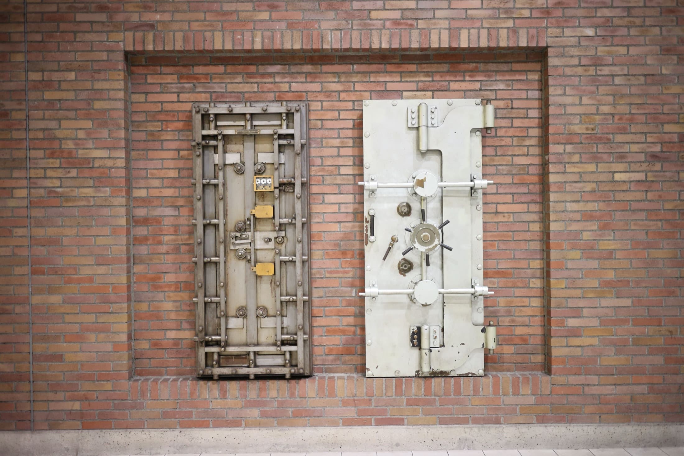 Une porte de coffre-fort ancienne, encastrée dans un mur de brique