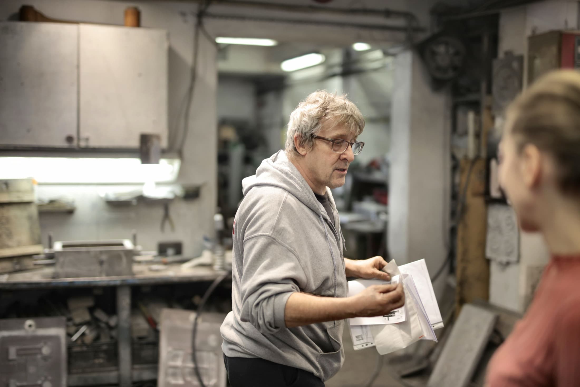 Un artisan explique une pièce à une collègue, dans son atelier