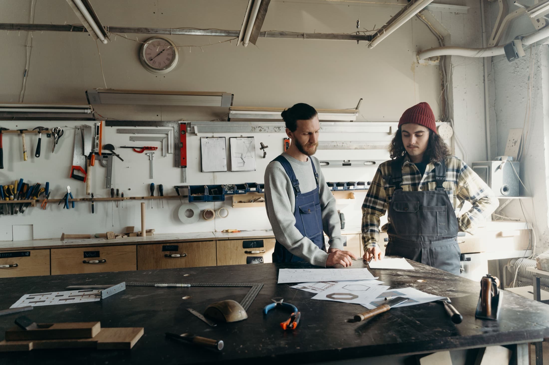 Deux artisans discutent d'une pièce au-dessus de leur plan de travail